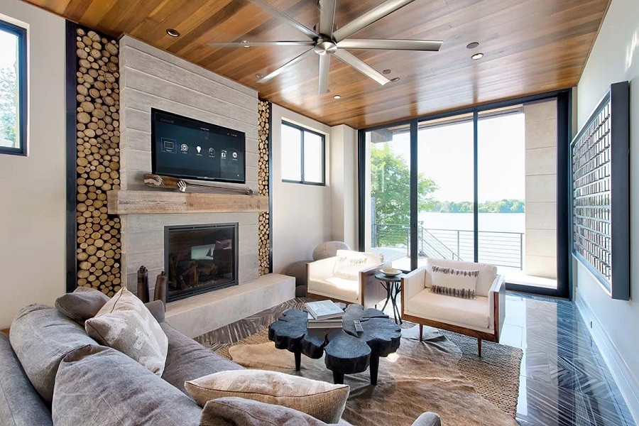 Elegant living room with mid-century furnishings overlooks deck and lake. 